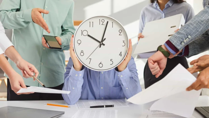 A group of people holding a clock over their heads.