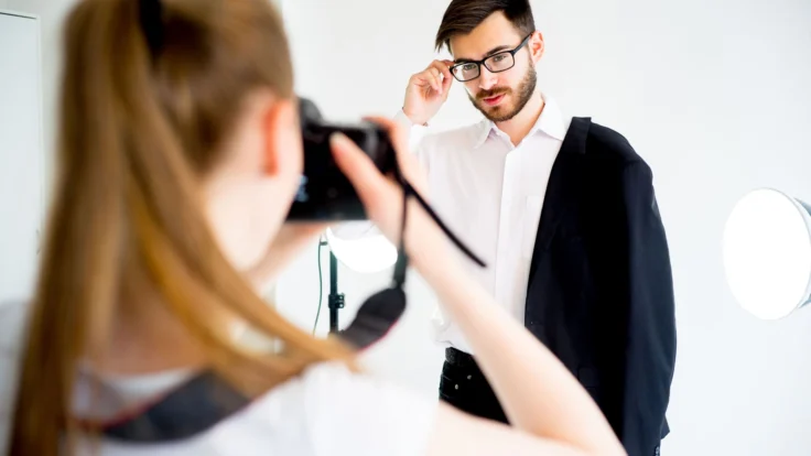 A man is taking a picture of a woman in a mirror.
