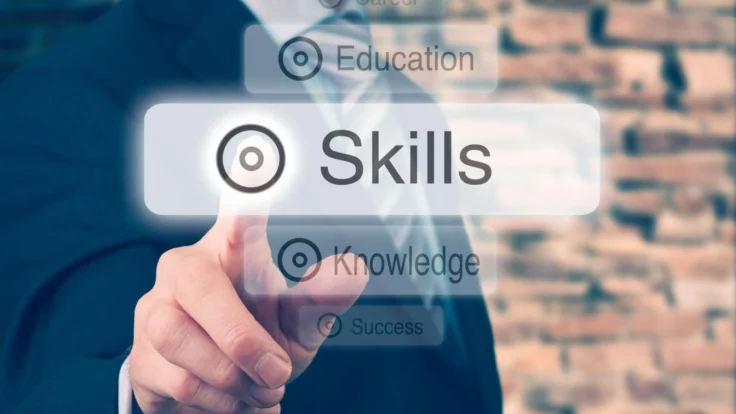A businessman is pointing at a button that says skills.