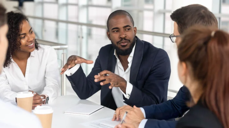 A group of business people sitting around a table.