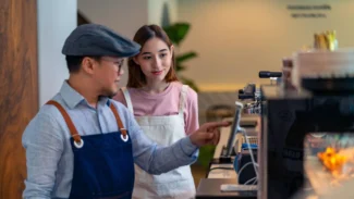 A man and a woman working at a coffee shop.