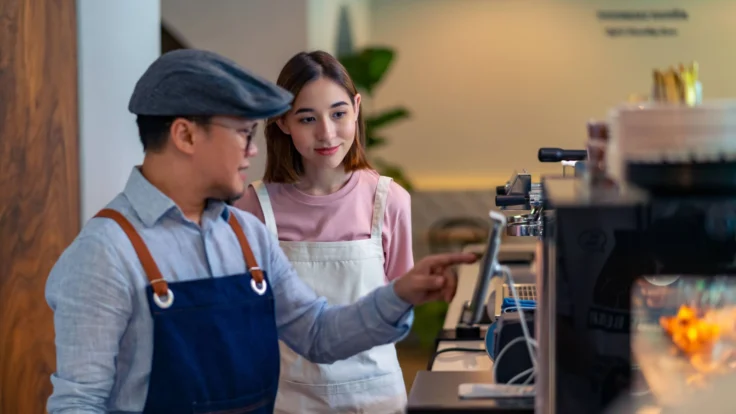 A man and a woman working at a coffee shop.