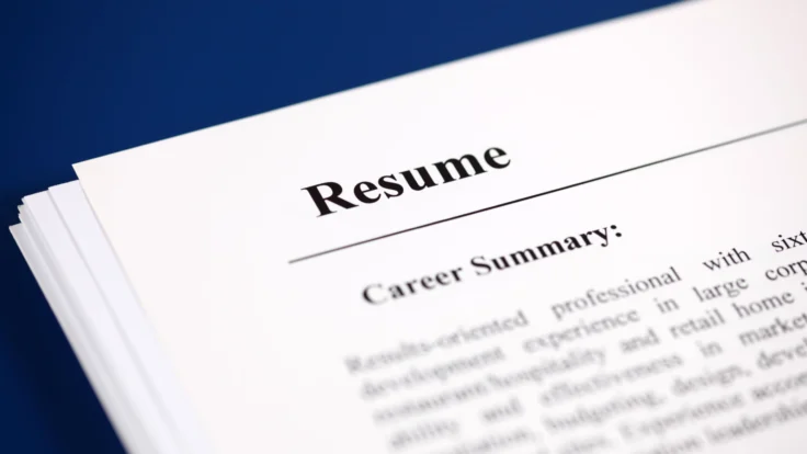 A close up of a resume on a blue background.