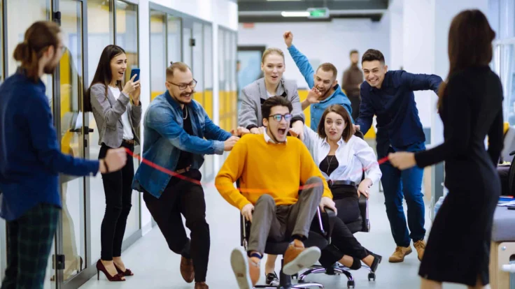A group of people playing tug of war in an office.