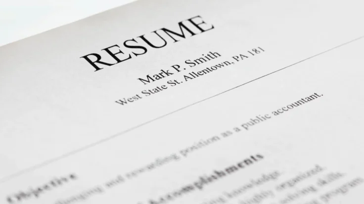 A close up of a resume on a book.