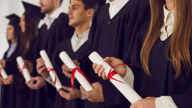 A group of graduates holding their diplomas.