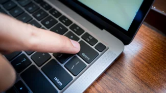 A person is typing on a laptop keyboard.