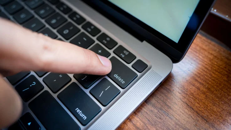 A person is typing on a laptop keyboard.