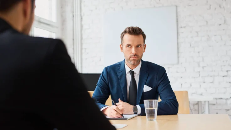 A man in a suit is talking to a man in a suit.